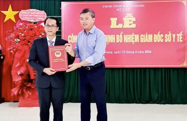 Phó Chủ tịch UBND tỉnh Kiên Giang Nguyễn Lưu Trung (bên phải) trao quyết định cho Đại tá Hồ Văn Dũng.