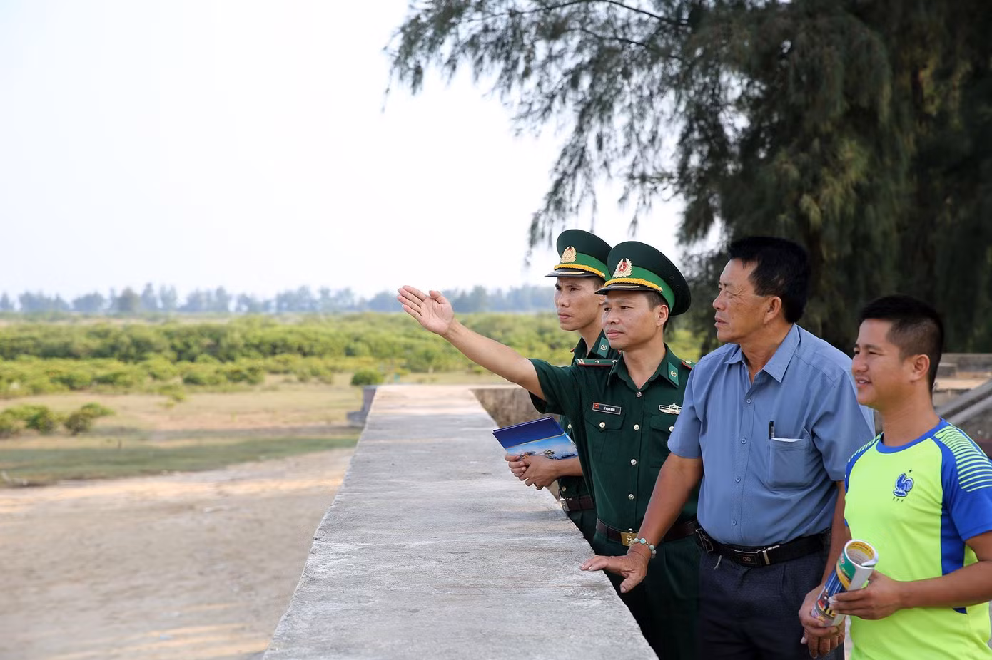 Ông Vũ Đình Phúc (thứ 2 bên phải) cùng với cán bộ Bộ đội Biên phòng tại cửa sông Bắc Luân.