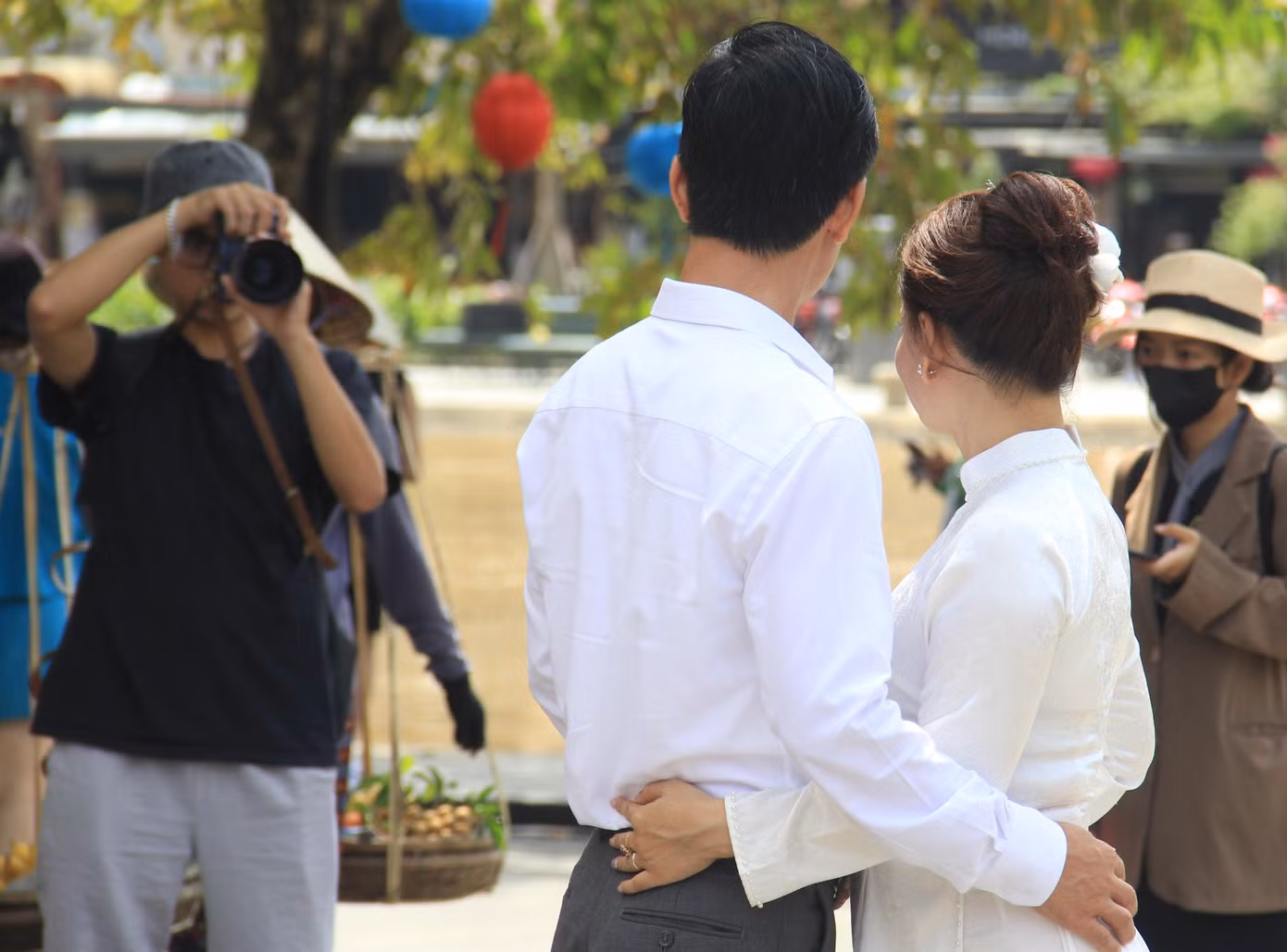 Một cặp đôi chụp hình cưới dưới Chùa Cầu trong tiết trời nắng nhẹ, mát mẻ.