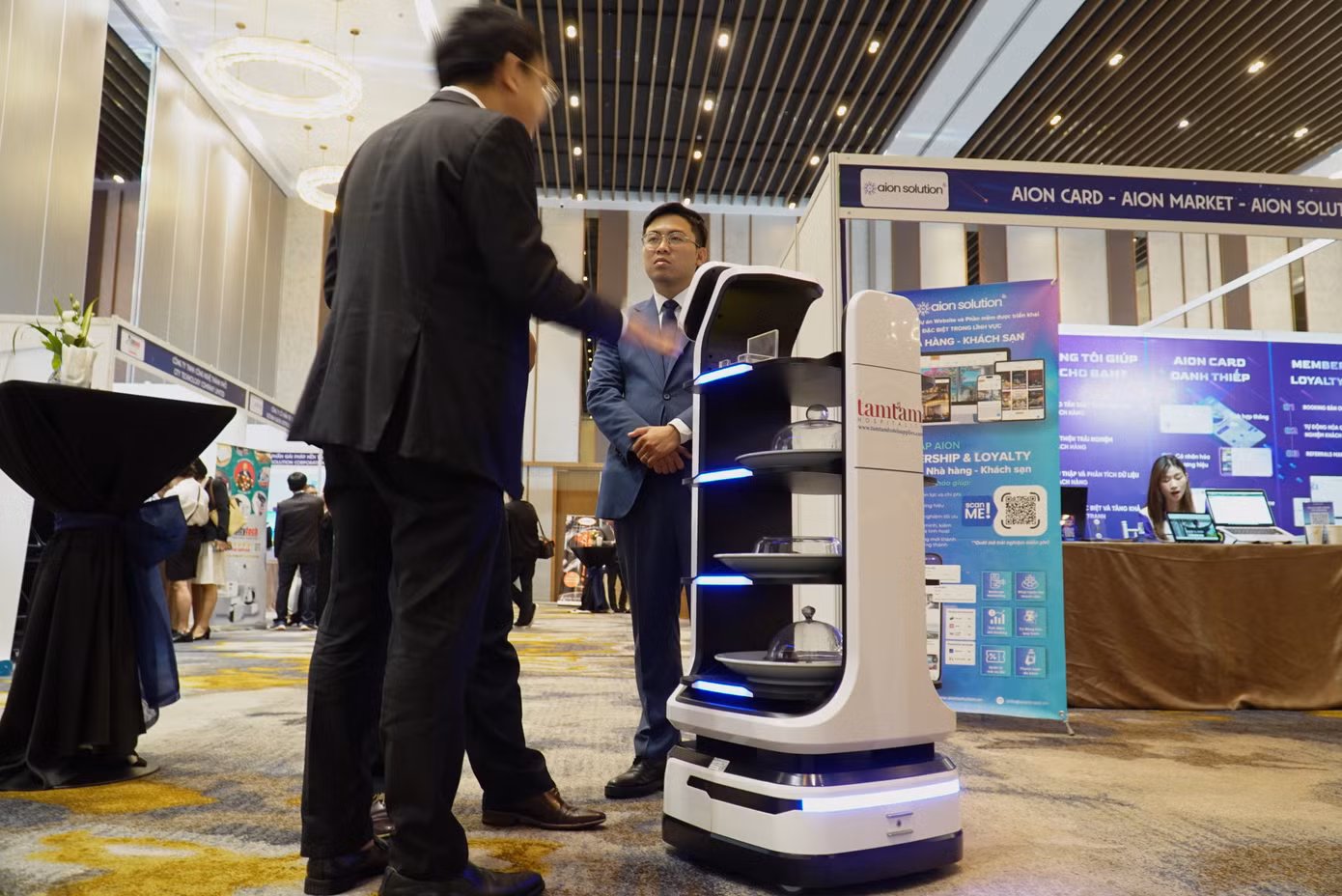 Robot “bồi bàn” này được một đơn vị ở miền Bắc mang tới triển lãm với chức năng chính như một bồi bàn trong khách sạn, nhà hàng. Khách hàng chọn thực đơn trên màn hình, robot sẽ chuyển thông tin về trung tâm xử lý, sau đó đến khu vực bếp/quầy ăn nhận món và trở lại đúng vị trí nơi khách ngồi. Ảnh: Thanh Hiền.