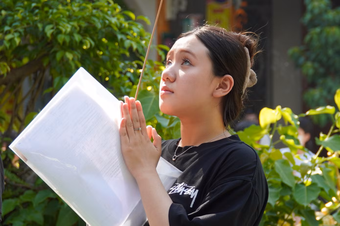 Vừa rời điểm thi, các thí sinh đến chùa với giấy tờ dự thi trong tay.