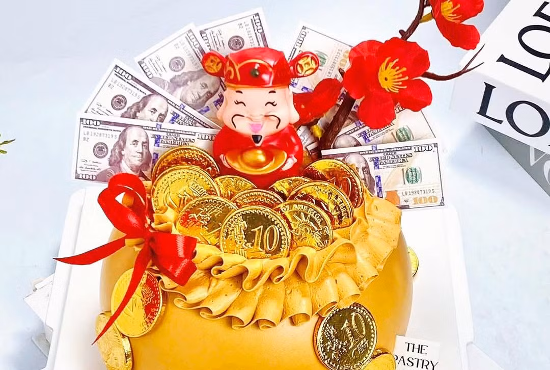 Quanh bánh đính thêm ông Thần tài, mèo Thần tài, đồng xu, tiền đô… Khách cũng có thể yêu cầu trang trí theo nhu cầu. Giá bán mỗi chiếc bánh tùy kích cỡ từ 150.000 - 400.000 đồng.