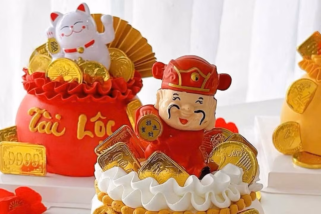 Quanh bánh đính thêm ông Thần tài, mèo Thần tài, đồng xu, tiền đô… Khách cũng có thể yêu cầu trang trí theo nhu cầu. Giá bán mỗi chiếc bánh tùy kích cỡ từ 150.000 - 400.000 đồng.