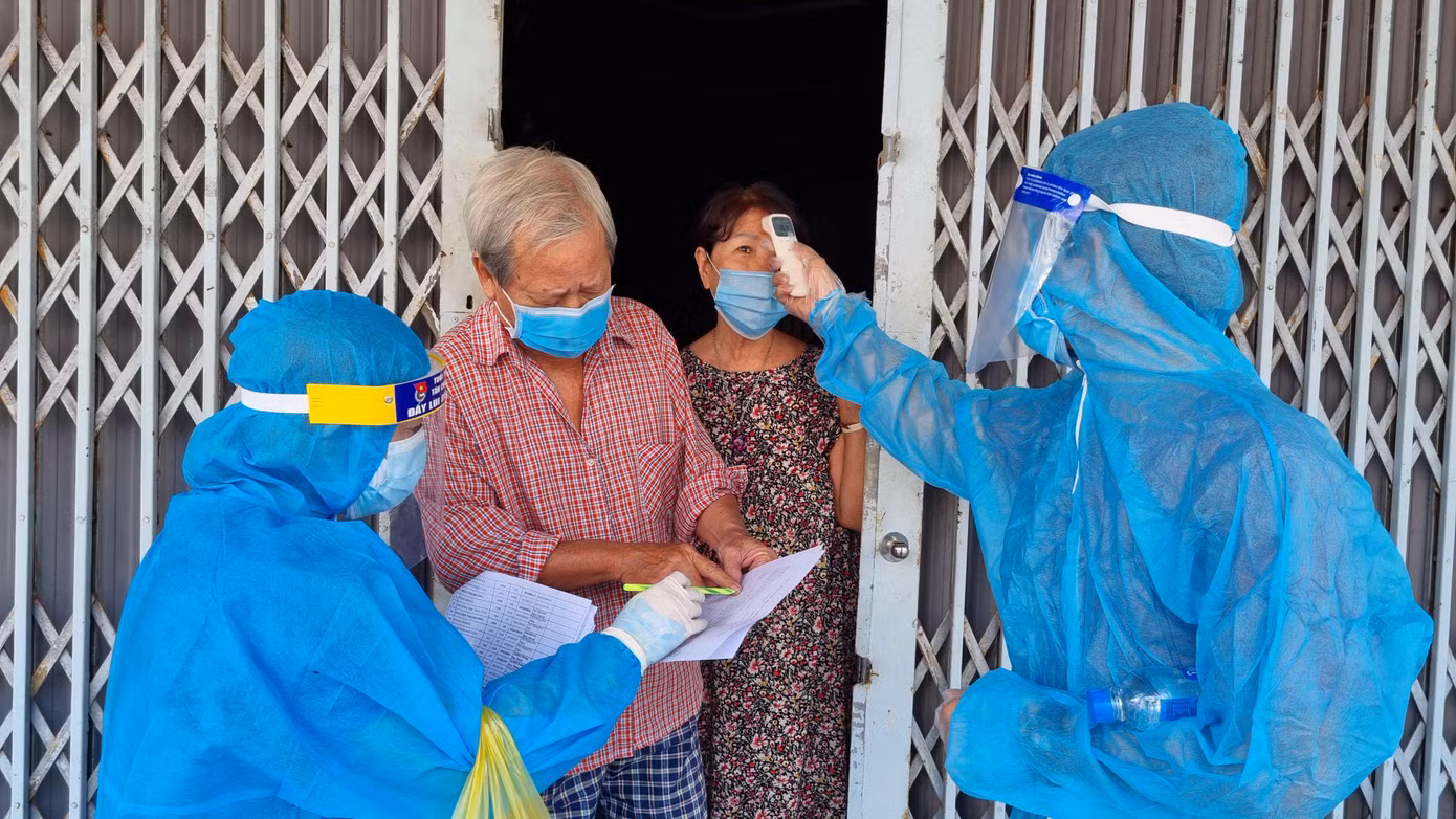 Nhân viên y tế kiểm tra sức khỏe cho người dân trong khu phong tỏa.
