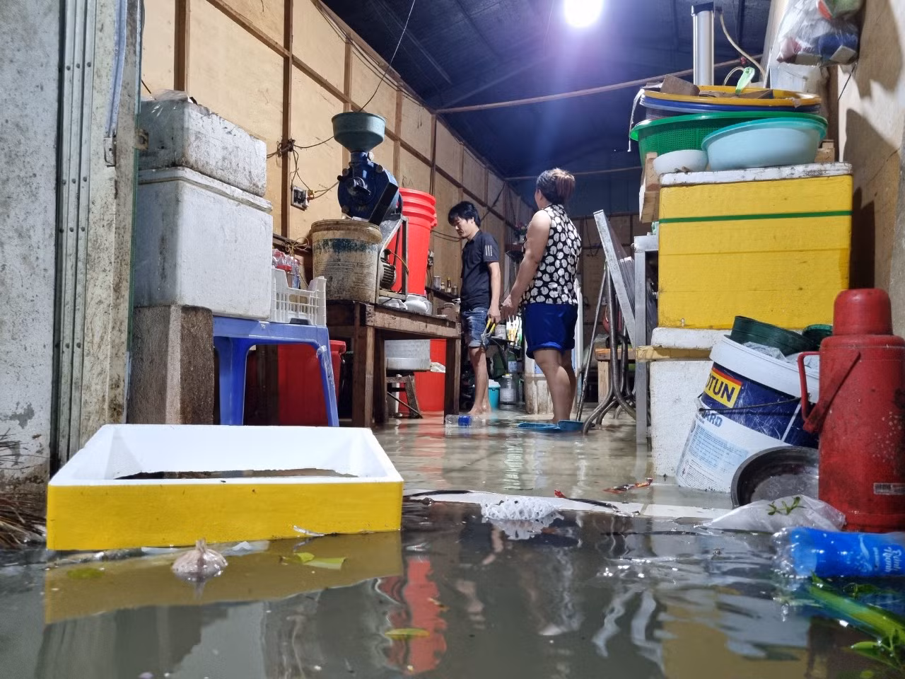 Nước tràn vào nhà dân rất nhanh. Các hộ dân tất bật cả tối dọn đồ đạc, kê gác những thiết bị điện lên để khỏi bị chập chạm.