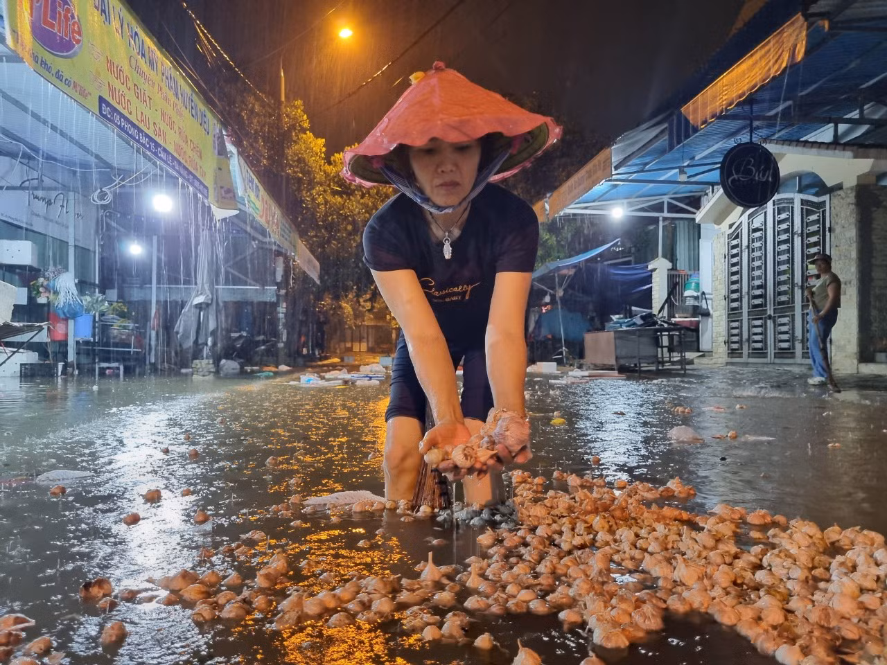 Chị Nguyễn Thị Diệu (phường Hoà Thọ Đông, quận Cẩm Lệ) thuê nhà để buôn bán rau củ quả, làm gà vịt gần chợ Hòa Cầm. Chiều tối nay thấy nước dâng, cả nhà chị hối hả dọn dẹp nhưng không thể nào dọn kịp vì nước lên nhanh. "Năm trước nước ngập cả mét, bao nhiêu tài sản bị hư sạch. Năm nay vừa vay tiền để đầu tư lại làm ăn, giờ lại chịu ngập", chị rệu rã. Trong ảnh: Những thùng tỏi không kịp kê gác đã bị ngâm nước, phải vứt bỏ.