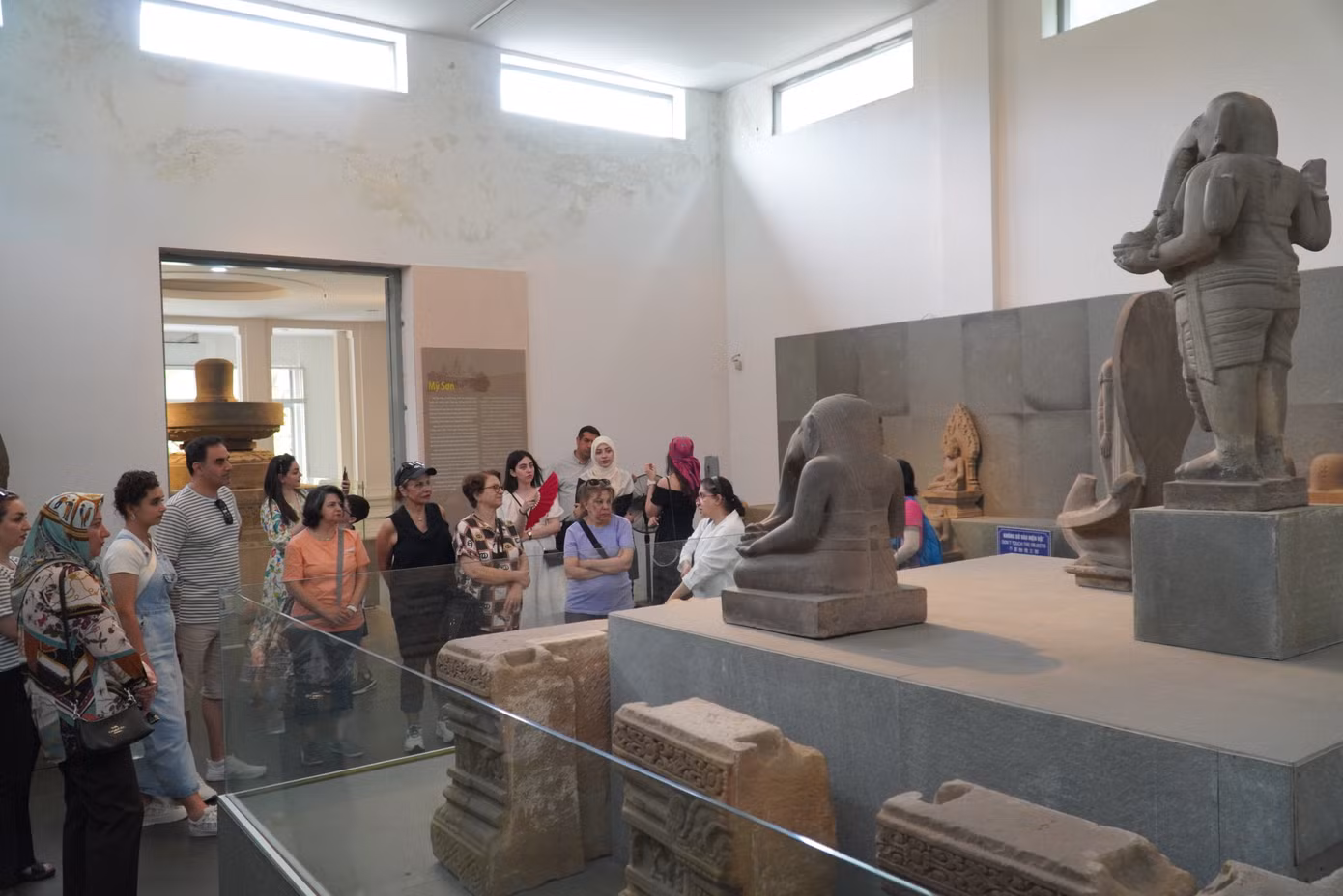 Du khách vây quanh tượng thần Ganesha (thế kỷ VII), xuất xứ Mỹ Sơn, Quảng Nam, chất liệu sa thạch. Tượng được phát hiện vào năm 1903 khi Viện Viễn Đông Bác Cổ Pháp (EFEO) tiến hành khảo cổ tại di tích Mỹ Sơn, và được đưa về lưu giữ tại bảo tàng từ năm 1918. Đây là một trong những tượng tròn hiếm hoi thể hiện vị thần ở dạng thức đứng, còn tương đối nguyên vẹn. Hiện vật được công nhận là Bảo vật quốc gia vào năm 2020. Ảnh: Thanh Hiền.