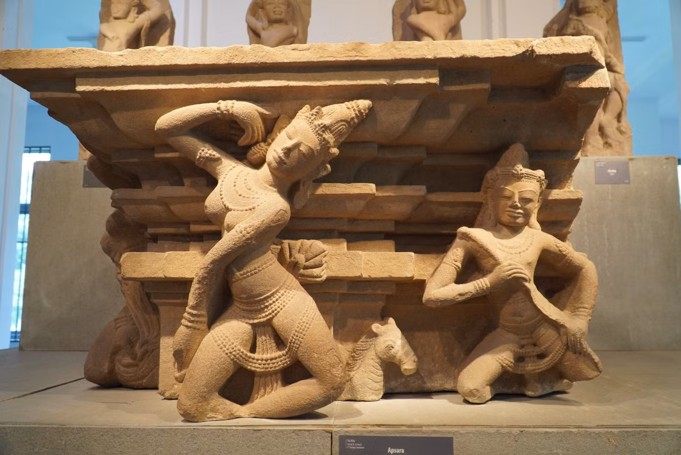 Apsara (thế kỷ X) xuất xứ Trà Kiệu, Quảng Nam, chất liệu sa thạch. Apsara là nàng tiên trong thần thoại Ấn Độ. Một góc đài thờ hiện đang trưng bày được điêu khắc nổi hai vũ nữ Apsara cùng hai nhạc công Gandharva đang chơi đàn. Ảnh: Thanh Hiền.