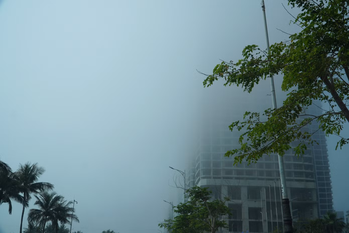 Các tầng trên của một cao ốc chìm trong sương mù. Theo người dân, sương mù kéo dài đến hơn 9h sáng.