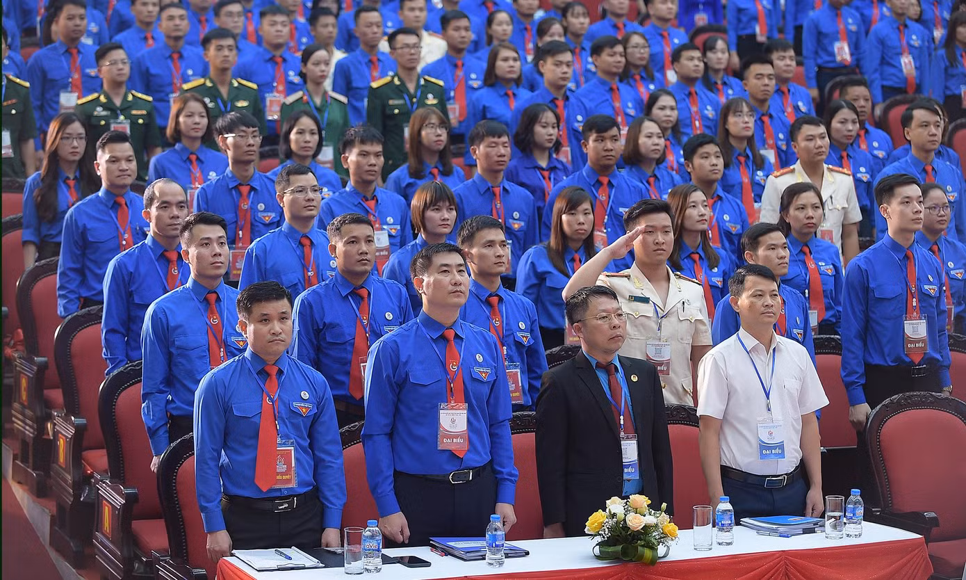 Các đại biểu tham dự phiên khai mạc thực hiện nghi lễ chào cờ. Ảnh: Xuân Tùng