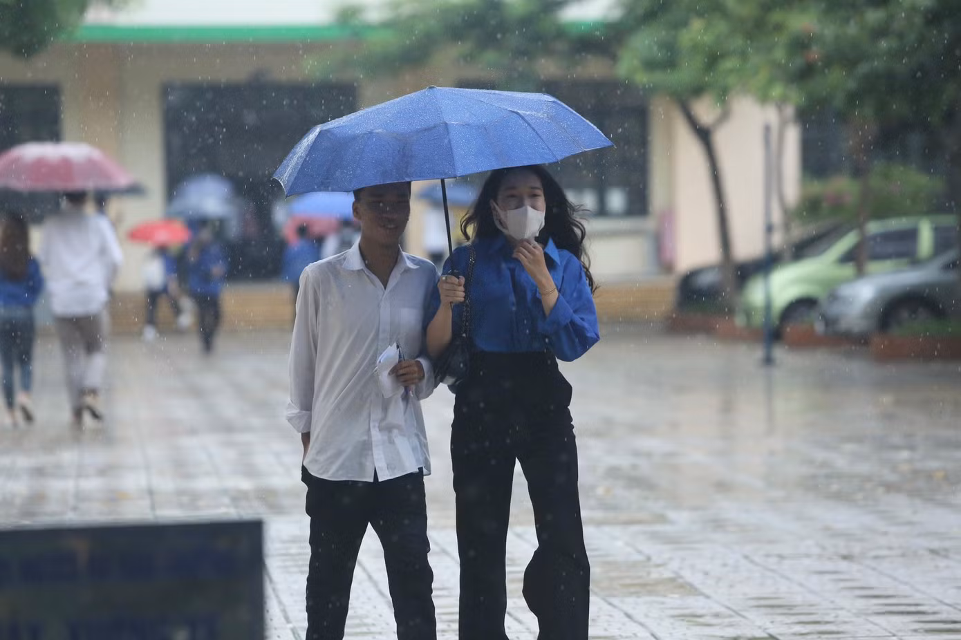 Dù trời mưa lớn, người ướt sũng nhưng các bạn áo xanh tình nguyện vẫn tươi cười động viên thí sinh