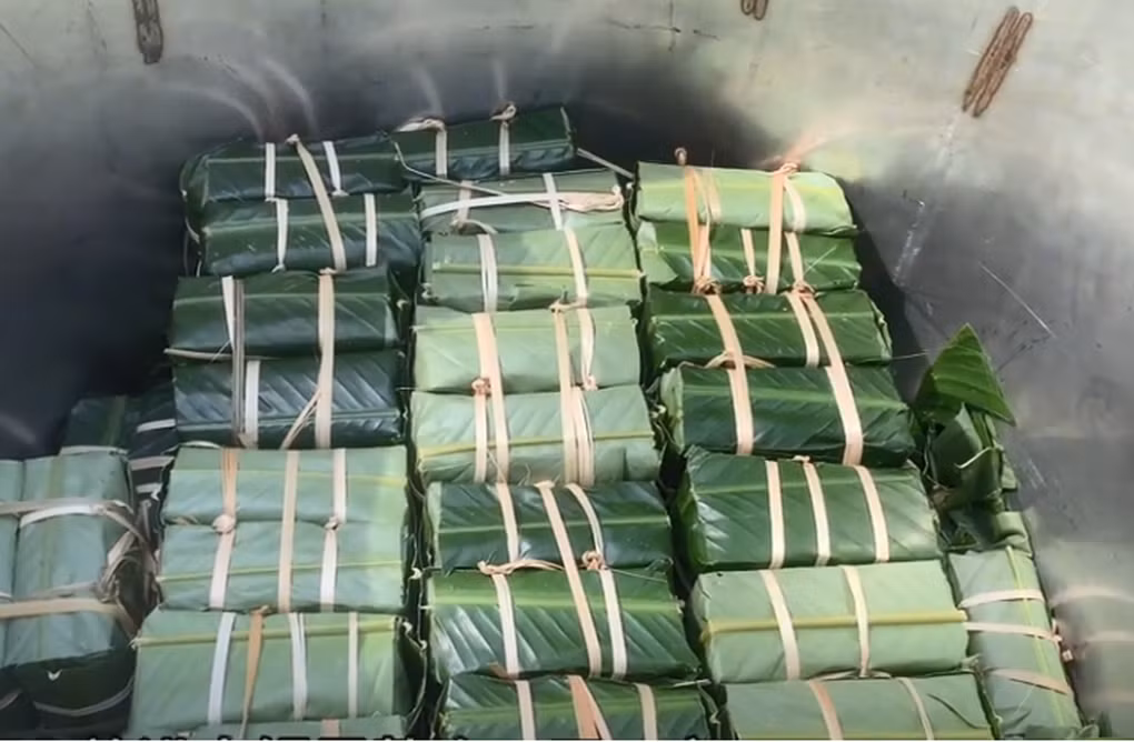 Các gia đình quây quần gói 100 chiếc bánh chưng (Ảnh cắt từ clip).