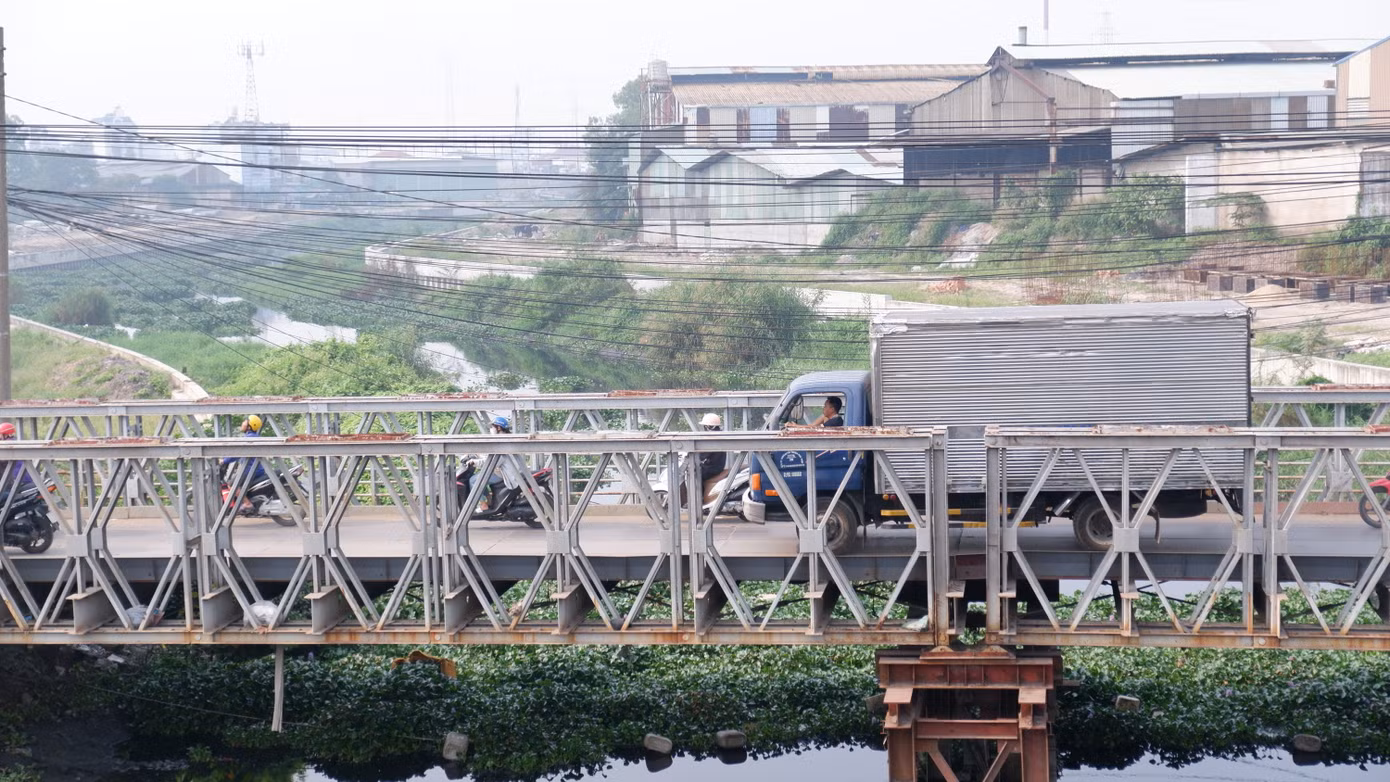 Trước khi có cầu mới, người dân phải đi qua cầu sắt cũ, chật hẹp và thường xuyên ùn tắc trong giờ cao điểm.