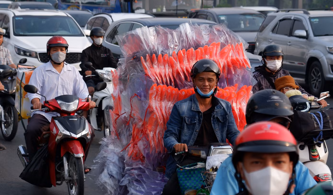 Người dân lỉnh kỉnh đồ đạc, rời TPHCM trên xe máy để về quê nghỉ Tết.
