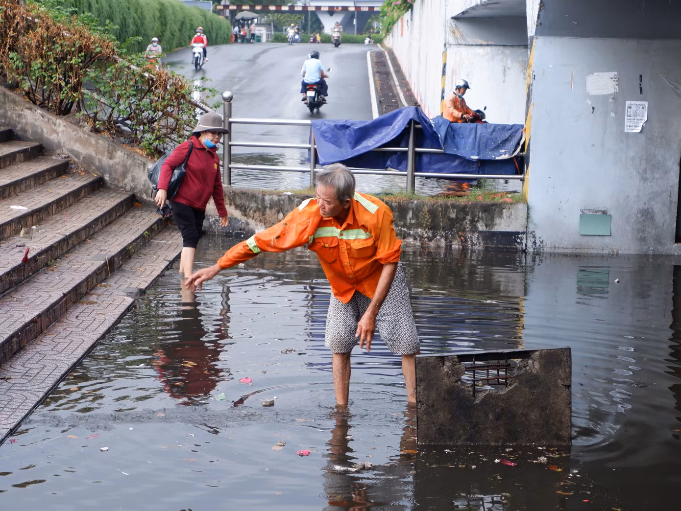 Người dân phải bật mở nắp cống để vớt rác, khơi thông dòng chảy để thoát nước.