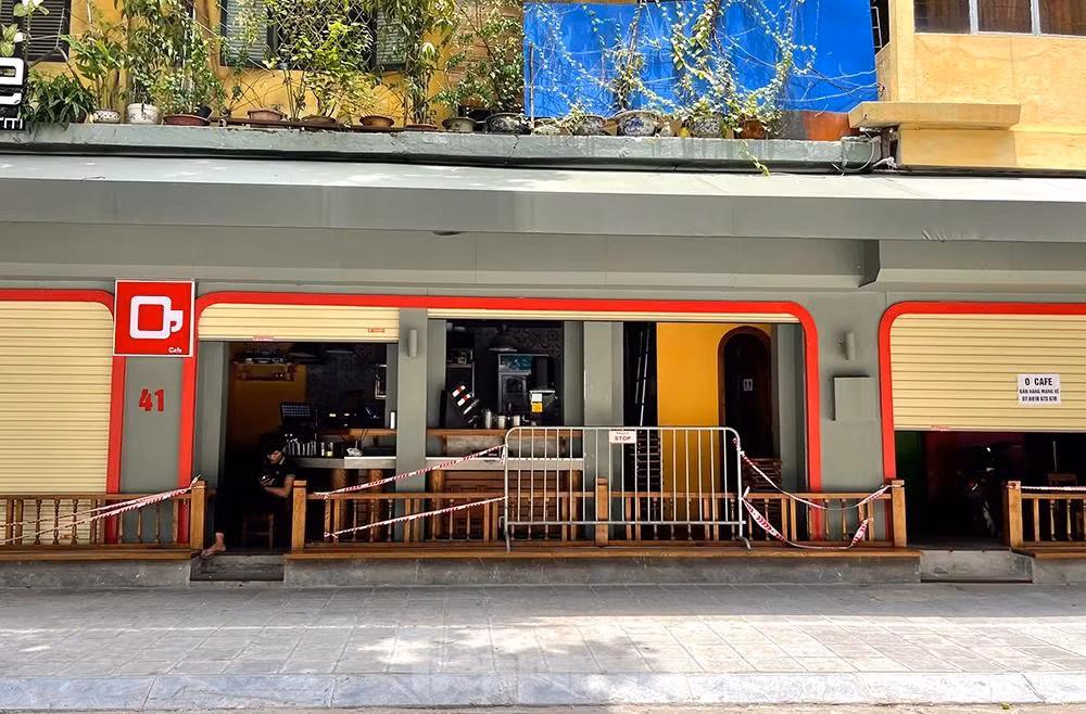 Hàng quán khắc khoải, mong chờ ngày được bán hàng trở lại. Ảnh chụp một quán cà phê trên phố Triệu Việt Vương với hàng rào ngăn cách, không cho khách ngồi, chỉ bán mang về.