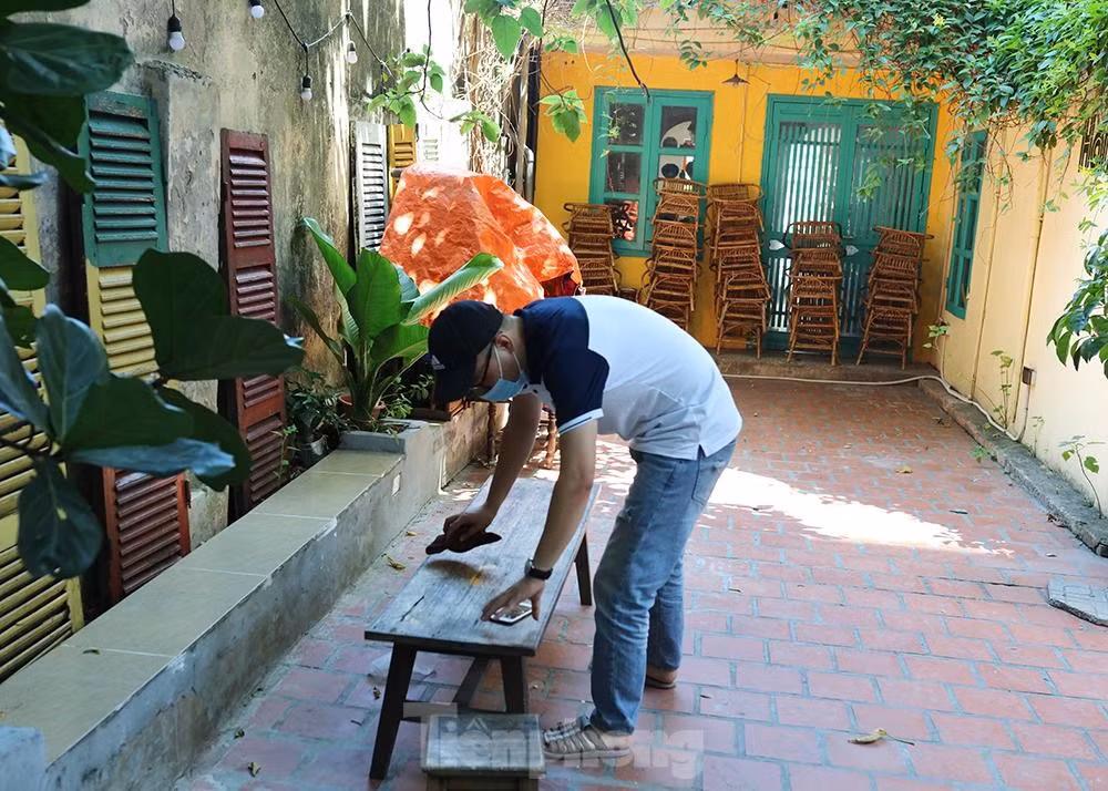 Anh Tiến đang lau chùi dọn dẹp bàn ghế quán để chờ ngày mở cửa hàng trở lại