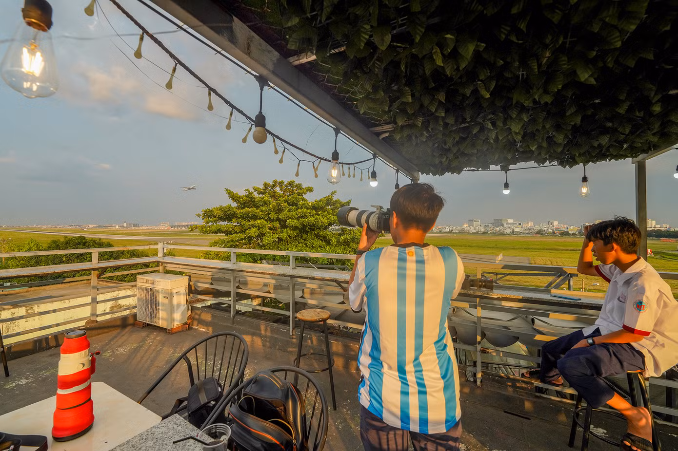 Nhiều bạn trẻ đầu tư thiết bị chụp ảnh chuyên dụng để bắt khoảnh khắc máy bay trên bầu trời. "Mình được nhân viên quán hướng dẫn khá rõ là không được sử dụng các loại đèn flash, thiết bị hắt sáng, phản quang khi chụp ảnh máy bay. Mình cũng có tìm hiểu nên tuân thủ những nguyên tắc cơ bản này khi chụp ảnh ở sân bay. Vào cuối tuần, mình hay cùng bạn bè vác máy ra đây săn ảnh máy bay", bạn Lê Phong Đạt (ngụ huyện Hóc Môn) chia sẻ.