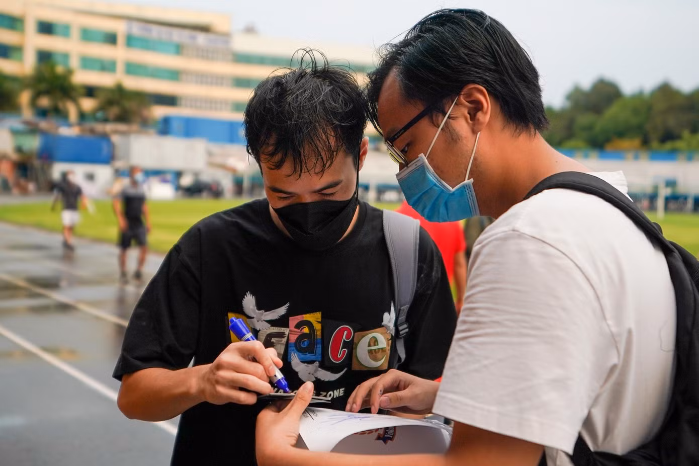 Tiền đạo Nguyễn Văn Toàn ký tặng người hâm mộ sau khi rửa sạch phần bột trắng trên mặt.