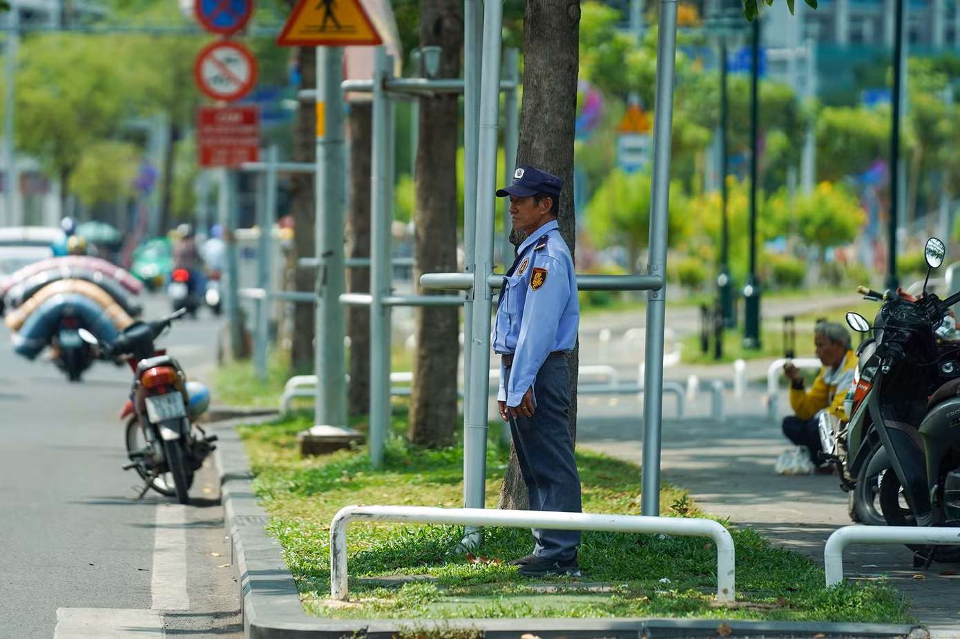 Anh bảo vệ này phải tìm bóng cây để trực gác dưới cái nóng oi bức giữa trưa.