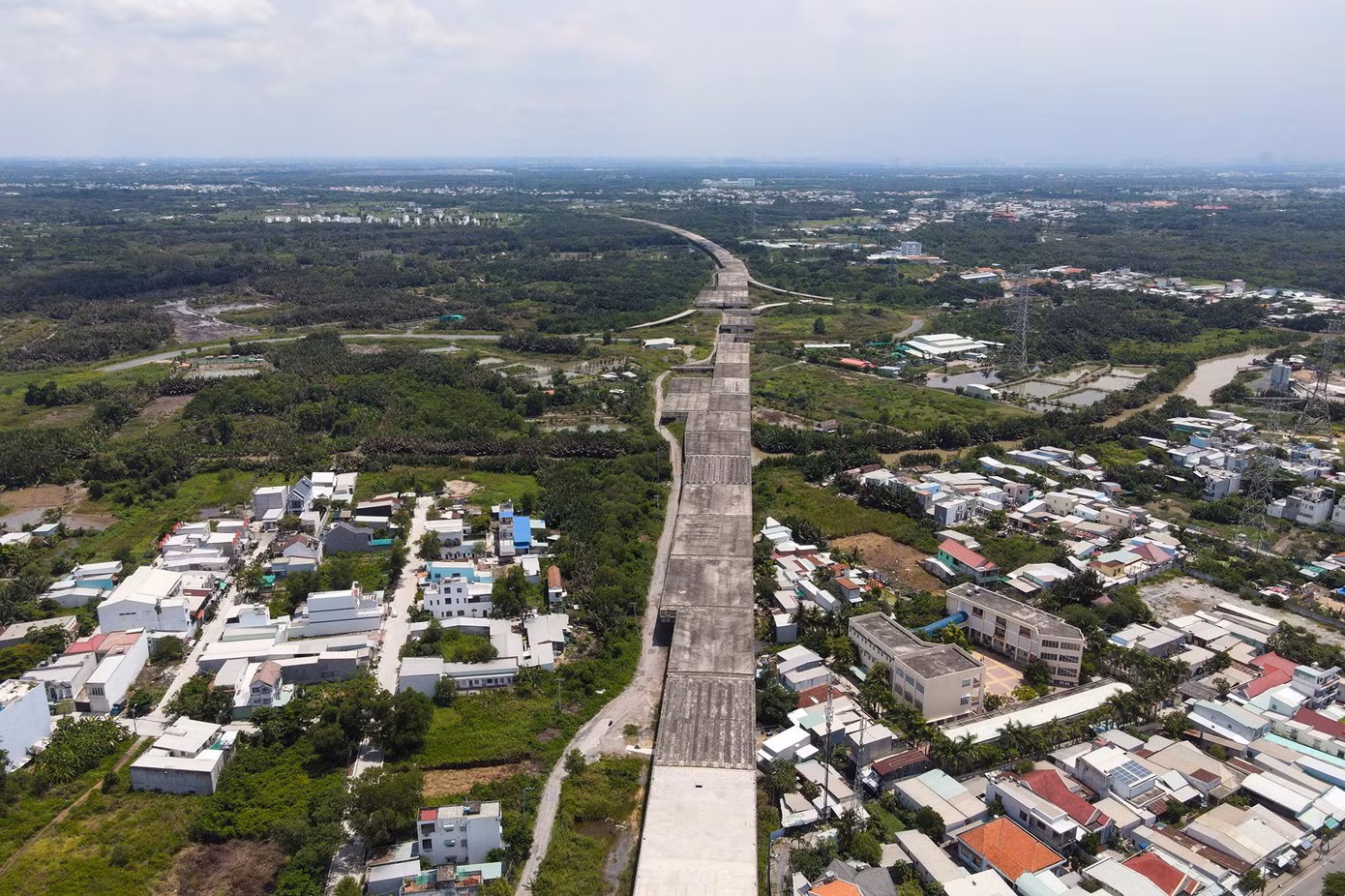 Hình ảnh một nút giao của cao tốc Bến Lức-Long Thành tại huyện Nhà Bè (TPHCM). Cao tốc Bến Lức - Long Thành nối huyện Bến Lức (Long An) với huyện Long Thành (tỉnh Đồng Nai) do Tổng công ty Đầu tư phát triển đường cao tốc Việt Nam (VEC) làm chủ đầu tư đã được khởi công. Cao tốc dài 58km, có 4 làn xe, 2 làn dừng khẩn cấp, vận tốc thiết kế 100km/h, tổng mức đầu tư giai đoạn 1 khoảng 31.320 tỉ đồng. Theo lãnh đạo VEC, dự án đã đạt 80% khối lượng thi công nhưng phải dừng lại từ giữa năm 2019 do vướng mắc về chính sách liên quan đến nguồn vốn.