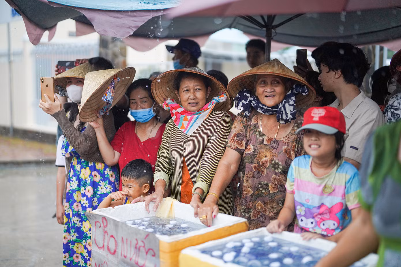 Người dân chuẩn bị nước uống đóng chai phát miễn phí cho du khách. Tuy cơn mưa khá to, ai nấy cũng đều phấn khởi, chào đón nhau bằng những nụ cười. Có thể thấy Nghinh Ông là ngày Tết của bà con vùng biển.