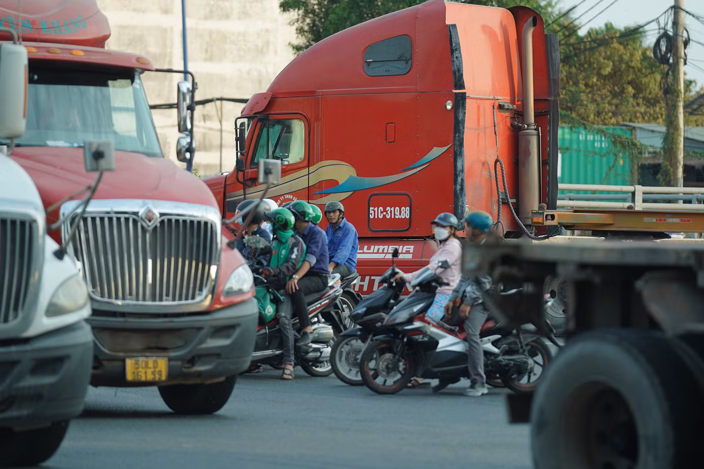 Người đi xe máy lọt thỏm vào những chiếc container, rơ móc...