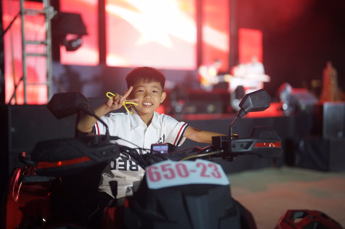 Bé Nguyễn Lê Thiên Phúc (9 tuổi, ngụ TP Biên Hoà, Đồng Nai) thích thú chụp ảnh cùng chiếc mô tô vượt địa hình. "Đó đến giờ người dân xung quanh đây muốn xem pháo hoa như thế nào phải vô trung tâm Quận 1 (TPHCM) nên này biết có bắn ở khu vực này thì háo hức lắm. Nhóc Phúc nó nghe pháo hoa nên đòi tôi phải dẫn vô đây từ chiều", phụ huynh của Phúc chia sẻ.