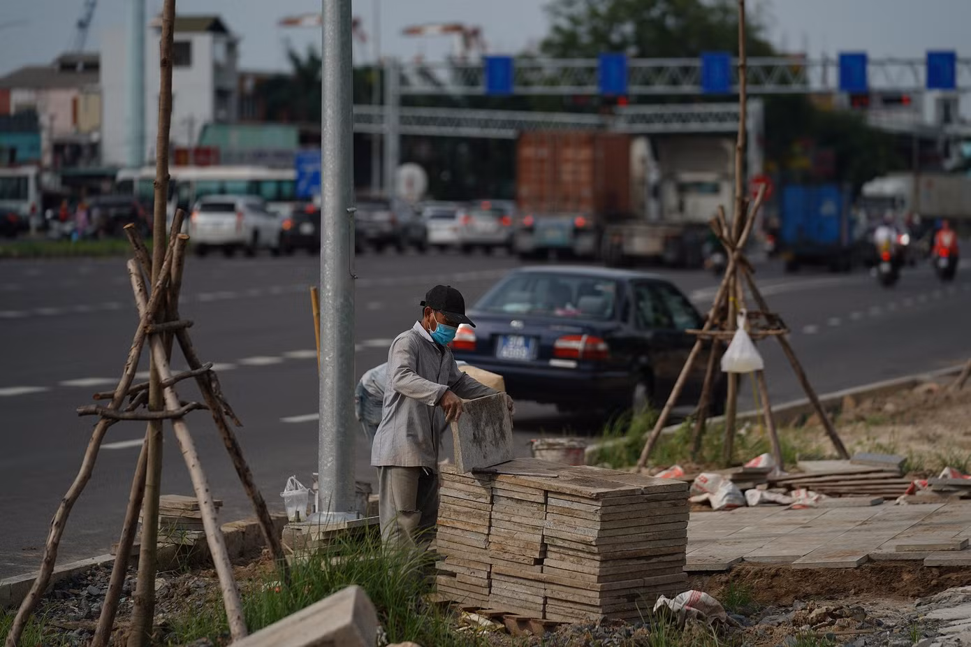 Một nhóm công nhân đang lát vỉa hè gần ngã tư Nguyễn Văn Linh - Nguyễn Thị Thập.