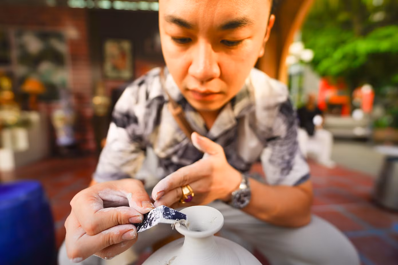 Anh Phạm Duy Sơn mới 34 tuổi nhưng đã có 15 năm làm gốm Bát Tràng đang chăm chú thao tác, trình diễn cho du khách xem quy trình làm ra một sản phẩm gốm.