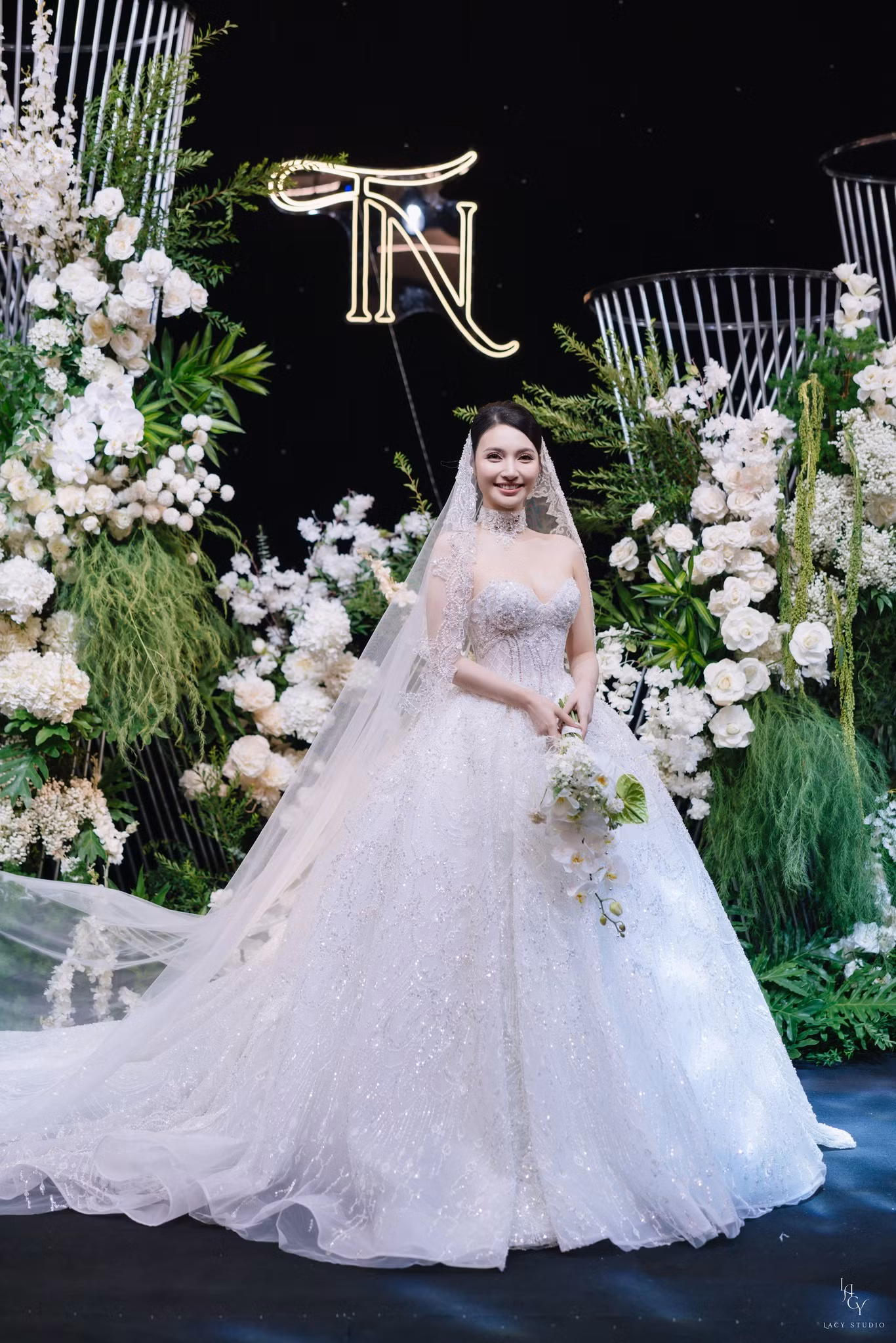 Trong đám cưới, Bích Thủy diện hai mẫu váy trị giá hơn 200 triệu đồng. Mẫu váy Ball Gown với phần tùng váy được nạm đá cùng kỹ thuật cắt laser để tạo độ bồng bềnh. Form váy dựng cấu trúc tôn lên vòng eo thon gọn với thiết kế corset siết eo tinh tế. Phần đính kết từ viền ngực kéo dài xuống tùng váy thu hút. Thiết kế này được thực hiện trong 6 tháng với 15 người thợ thủ công lành nghề và hơn 10.000 viên pha lê được nạm thủ công.