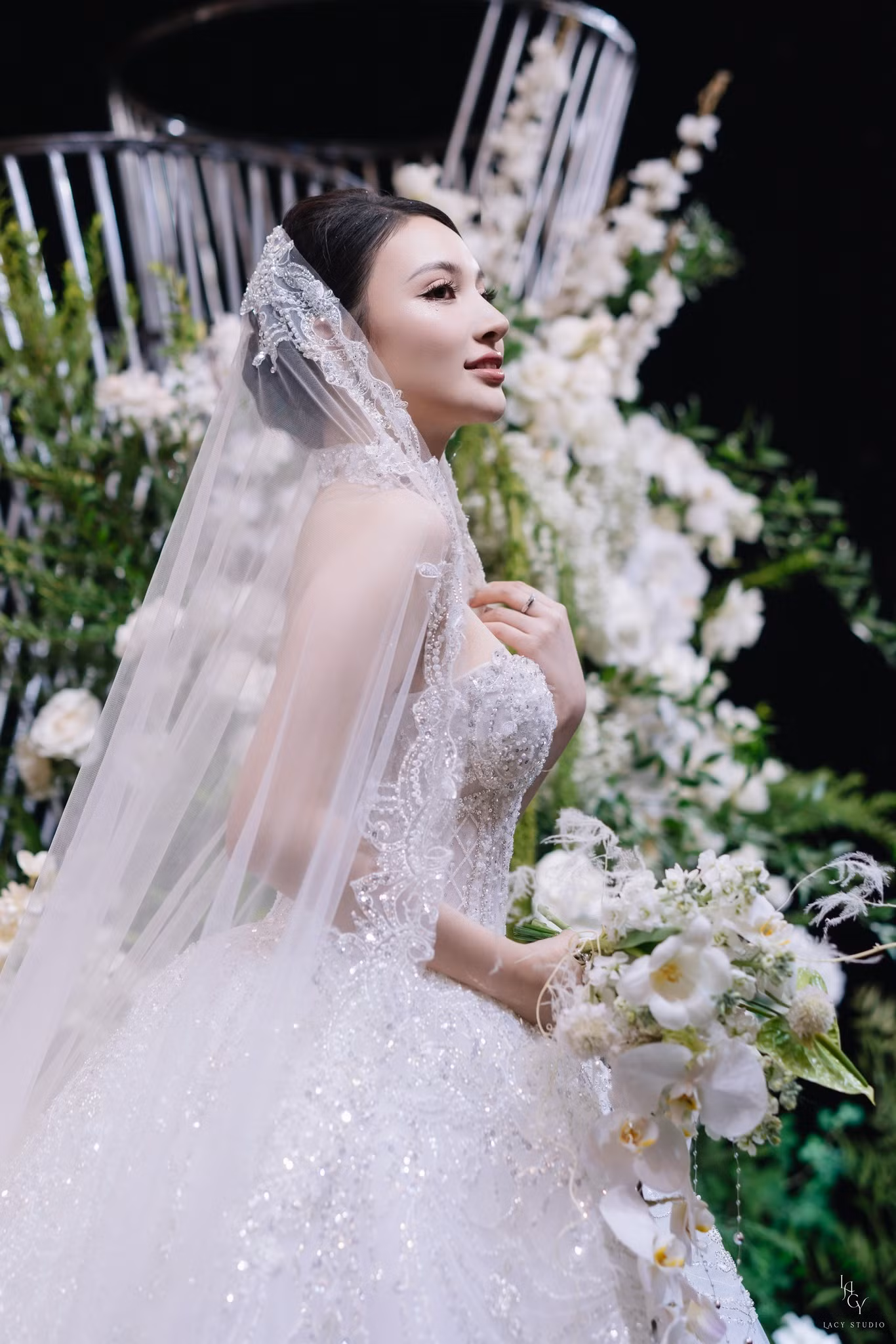 Trong đám cưới, Bích Thủy diện hai mẫu váy trị giá hơn 200 triệu đồng. Mẫu váy Ball Gown với phần tùng váy được nạm đá cùng kỹ thuật cắt laser để tạo độ bồng bềnh. Form váy dựng cấu trúc tôn lên vòng eo thon gọn với thiết kế corset siết eo tinh tế. Phần đính kết từ viền ngực kéo dài xuống tùng váy thu hút. Thiết kế này được thực hiện trong 6 tháng với 15 người thợ thủ công lành nghề và hơn 10.000 viên pha lê được nạm thủ công.