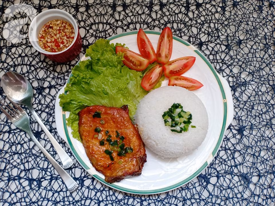 Cơm tấm sườn kết hợp giữa cơm tấm và thịt lợn nướng ướp gia vị đậm đà. Ảnh: AFamily.