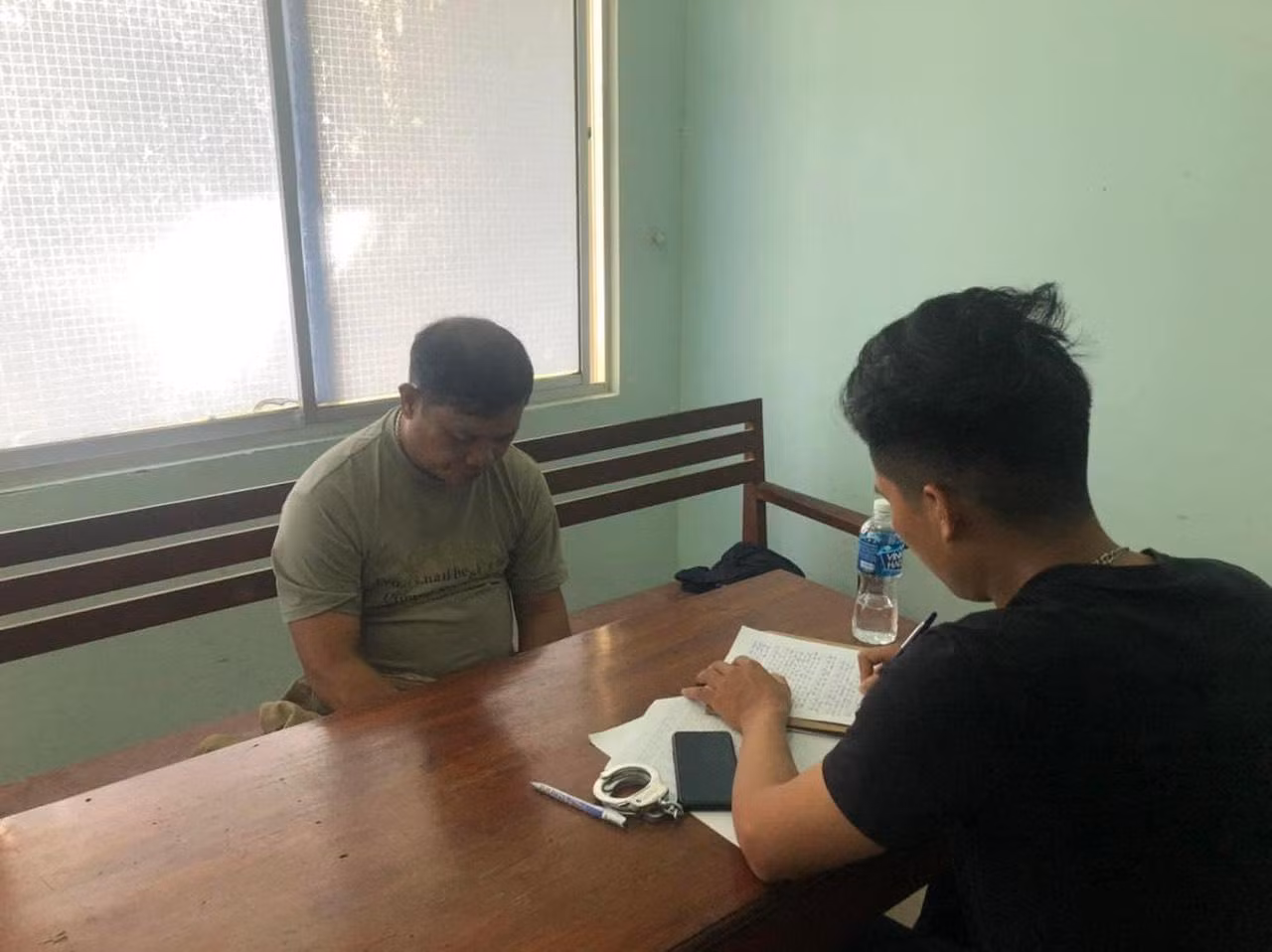 Đối tượng Đặng Văn Vinh (bên trái ảnh) tại cơ quan công an. Ảnh công an cung cấp.