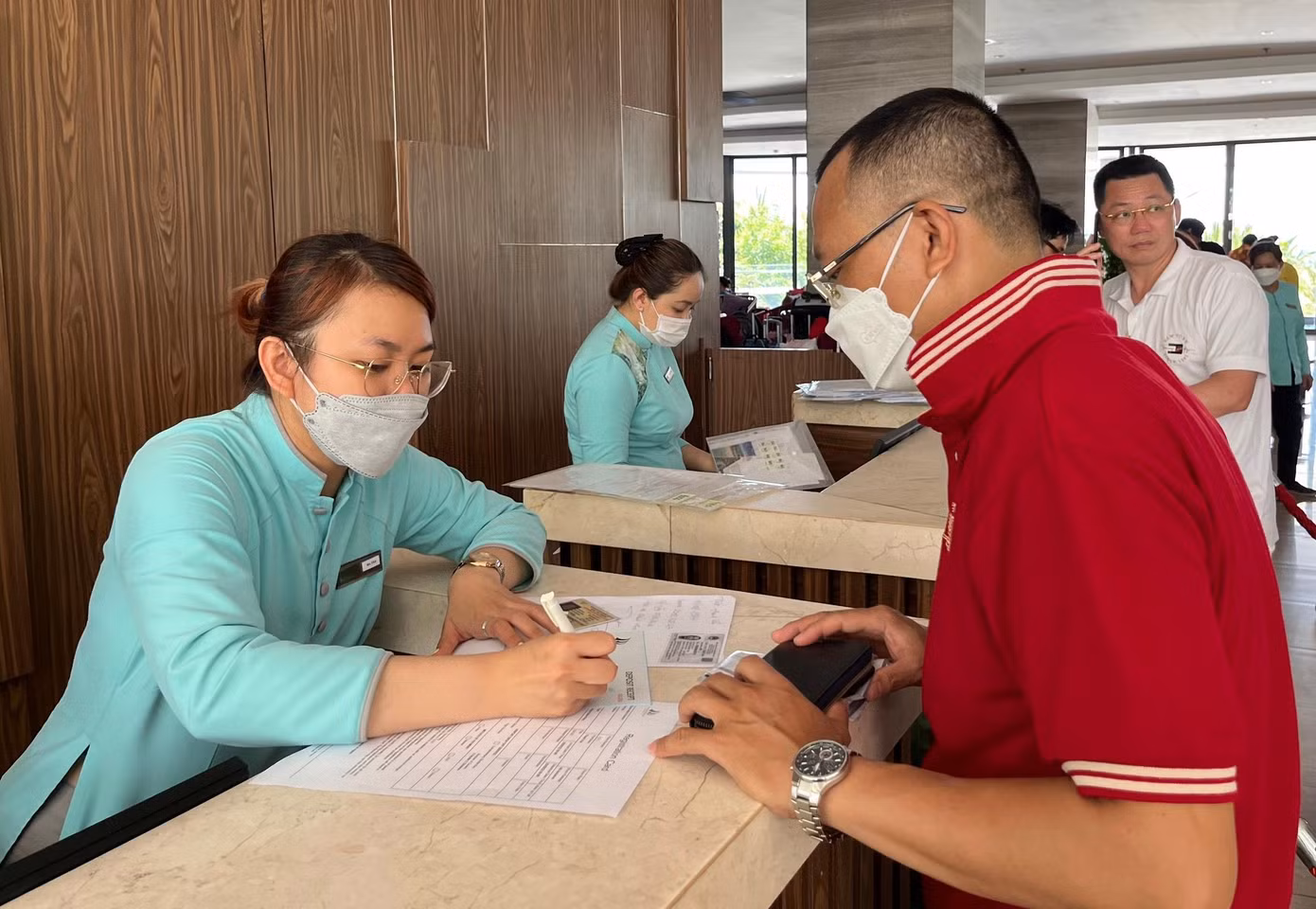 Nhân viên khu nghỉ dưỡng Cam Ranh Riviera tại Bãi Dài làm thủ tục nhận phòng cho khách