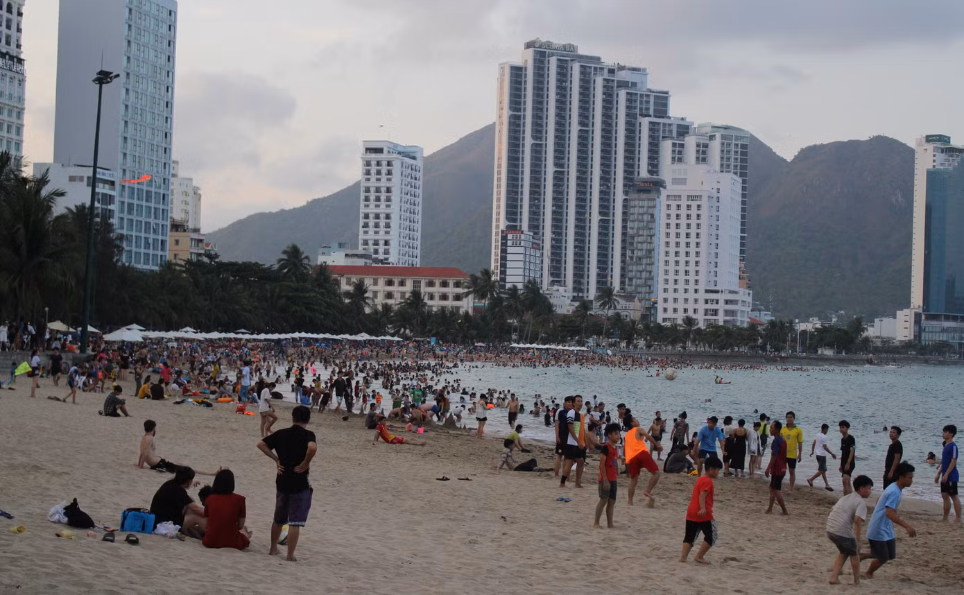 Bãi biển Nha Trang đông kín khách vui chơi, tắm biển.