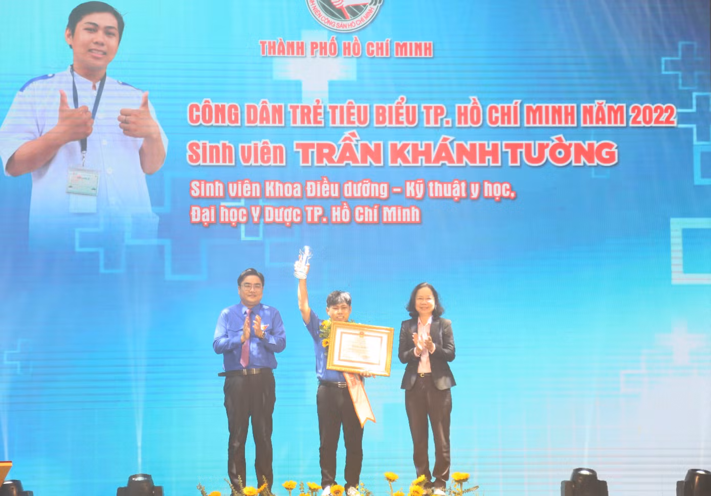 Trần Khánh Tường, sinh viên khoa Điều dưỡng - Kỹ thuật y học, trường ĐH Y Dược TPHCM nhận hoa và bằng khen tại buổi lễ vinh danh.
