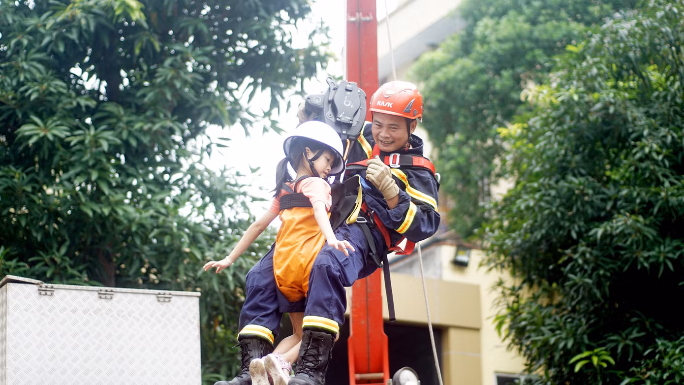 Các em nhỏ được cán bộ, chiến sĩ PCCC&amp;CNCH hướng dẫn thoát nạn bằng dây.