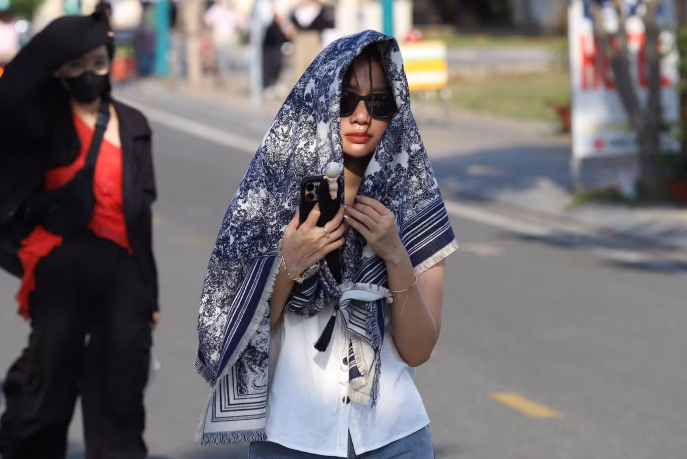 Một người hâm mộ nữ đội nắng chờ đợi thần tượng biểu diễn.