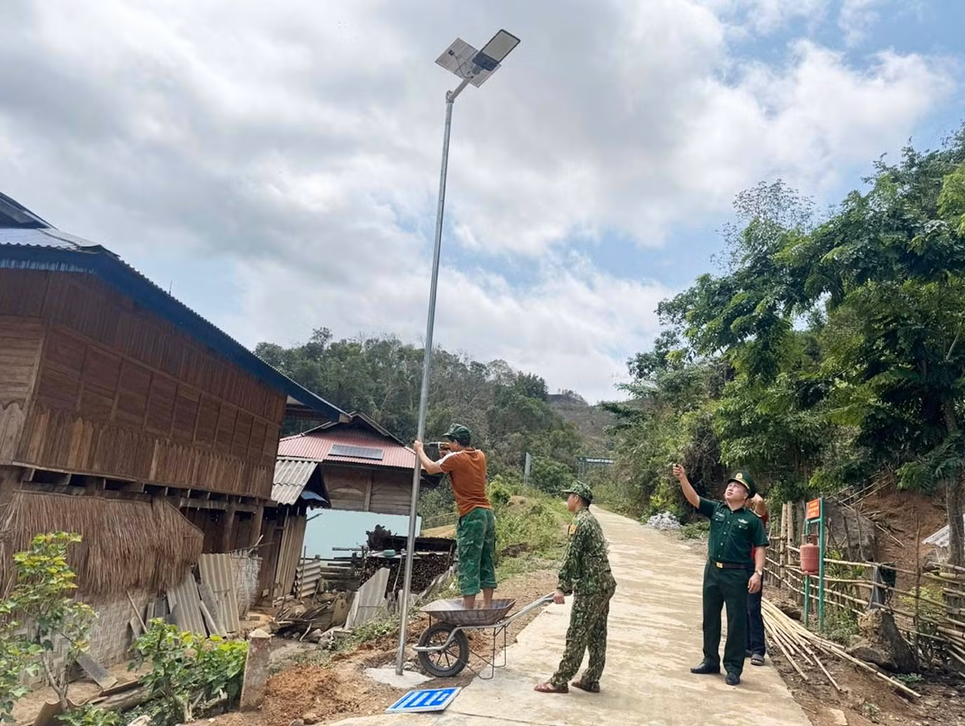 Các chiến sĩ đồn biên phòng Pa Thơm đang lắp đặt cột đèn do Chùa Ba Vàng tặng bà con.