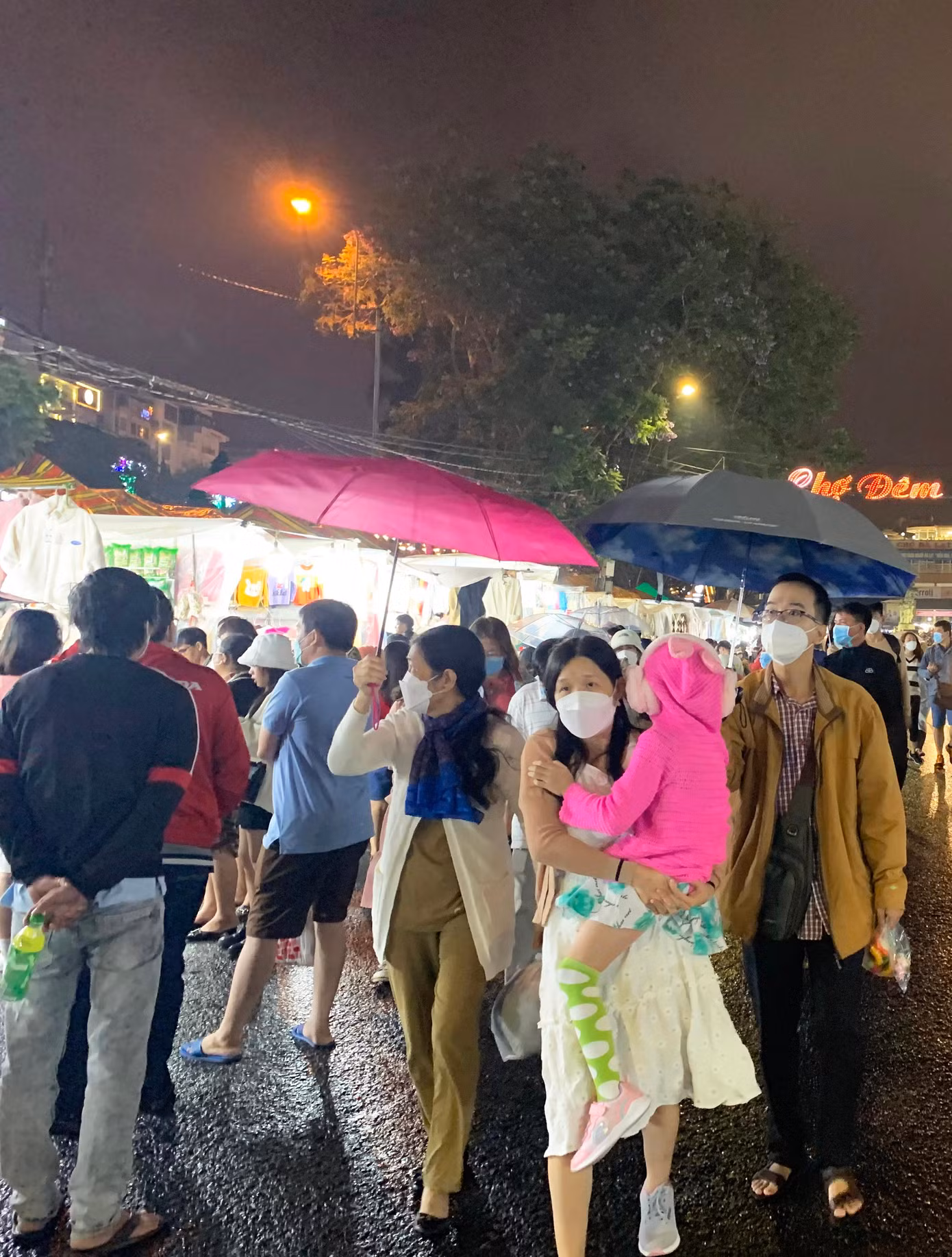 Du khách bung dù che mưa