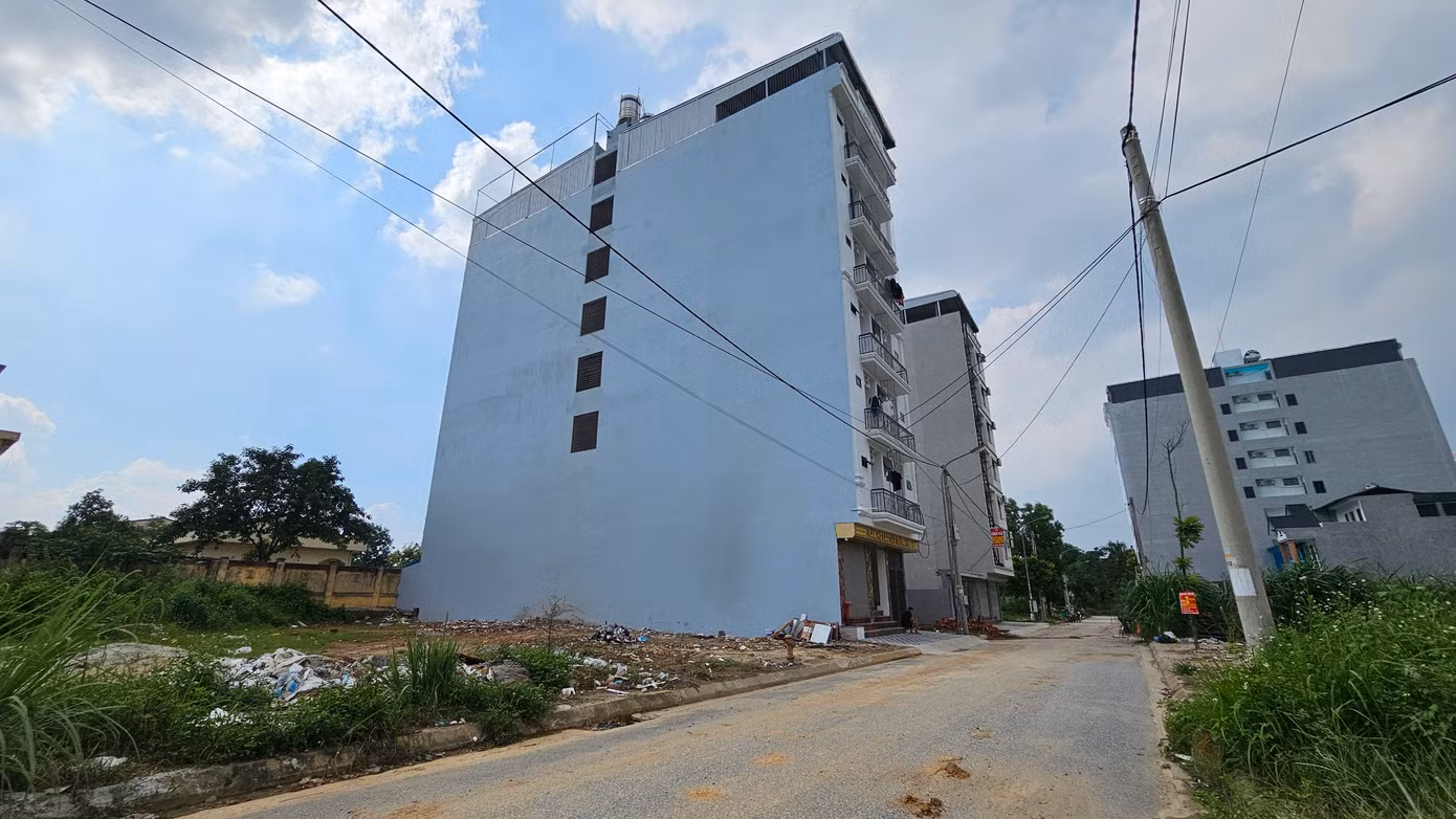 Người dân xung quanh tiết lộ, tòa nhà (trong cùng) cao 8 tầng có diện tích 200m2 bao gồm 60 phòng đã được bán với giá 23,5 tỷ đồng mới đây. Trong đó, mỗi phòng được bố trí như một căn hộ bao gồm phòng ngủ, giường, tủ, bếp ăn, nhà vệ sinh và nơi phơi quần áo.