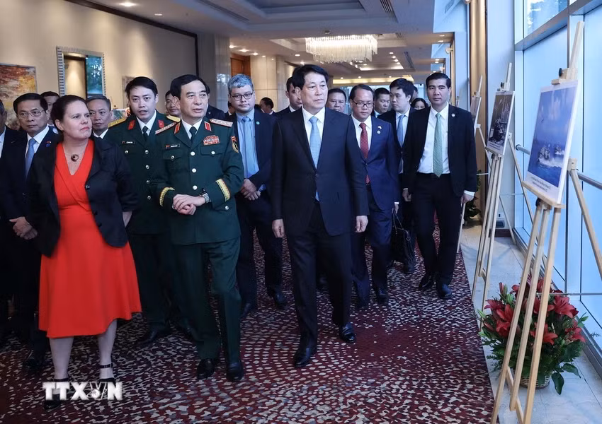 Chủ tịch nước Lương Cường và các đại biểu xem trưng bày ảnh về thành tựu của Quân đội nhân dân Việt Nam qua 80 năm xây dựng, trưởng thành và phát triển. (Ảnh: Lâm Khánh/TTXVN