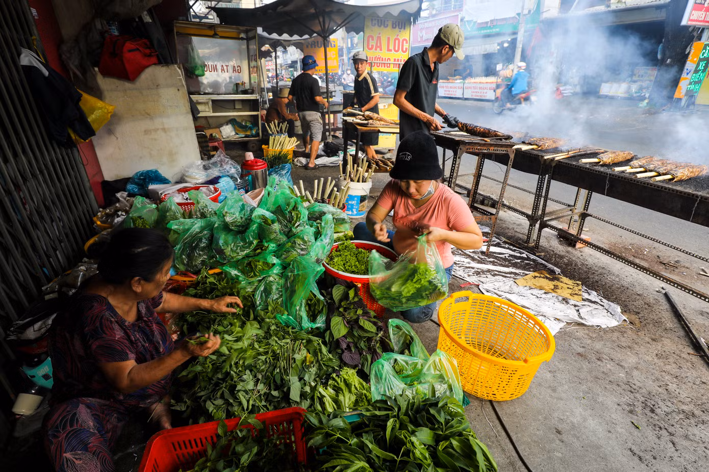Kề bên khu vực nướng cá, những nhân viên đang tất bật chuẩn bị rau thơm, pha chế mắm nêm, cho bún vào các túi nhỏ để bán kèm với cá lóc nướng.