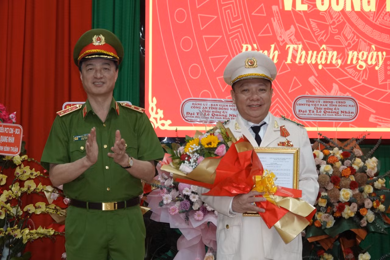 Trung tướng Nguyễn Duy Ngọc - Ủy viên Ban Chấp hành Trung ương Đảng, Thứ trưởng Bộ Công an trao quyết định và tặng hoa chúc mừng Đại tá Lê Quang Nhân.