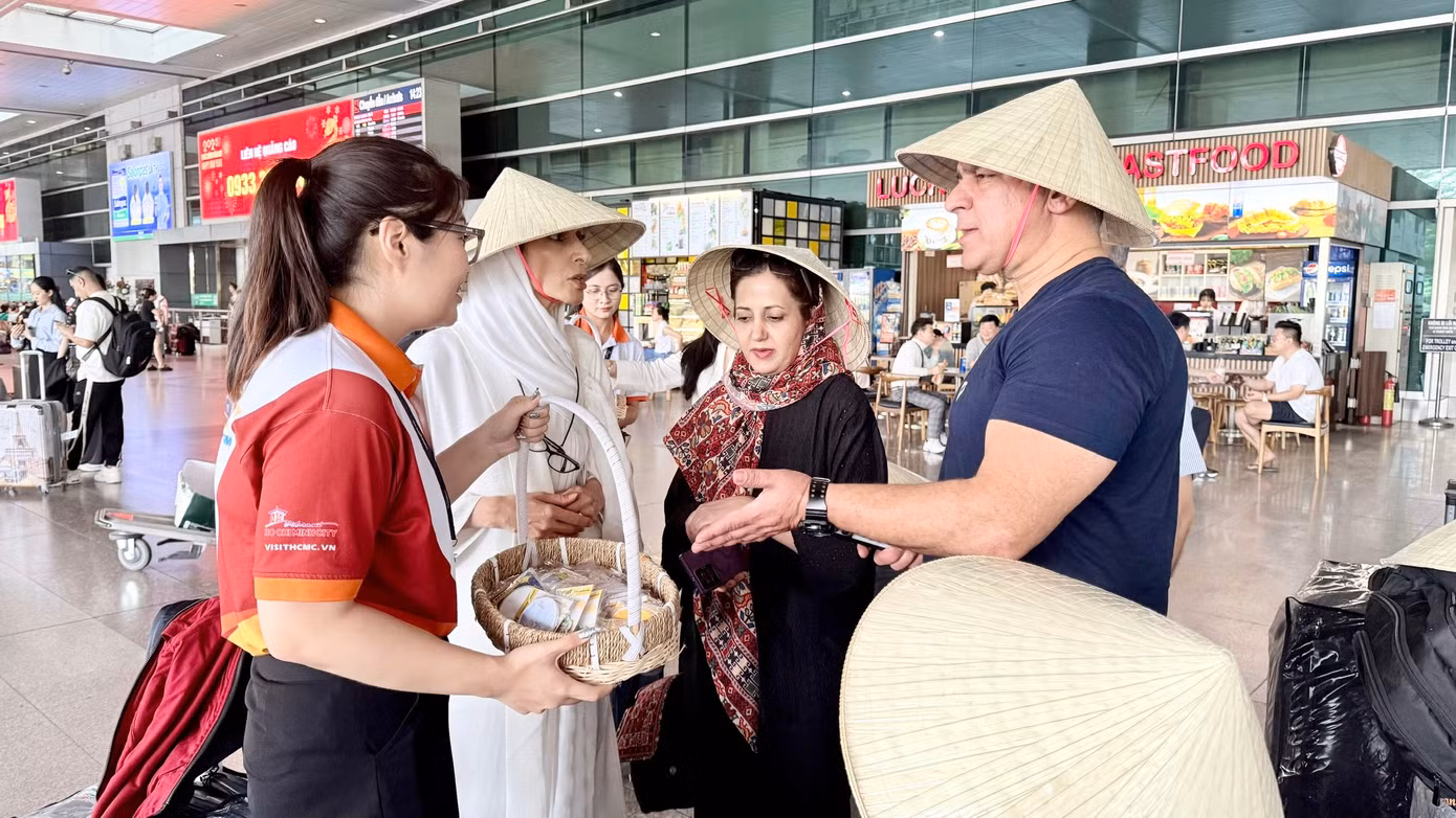 Du khách Iran đang nhận quà lưu niệm do đại diện Sở Du lịch TPHCM trao tặng.