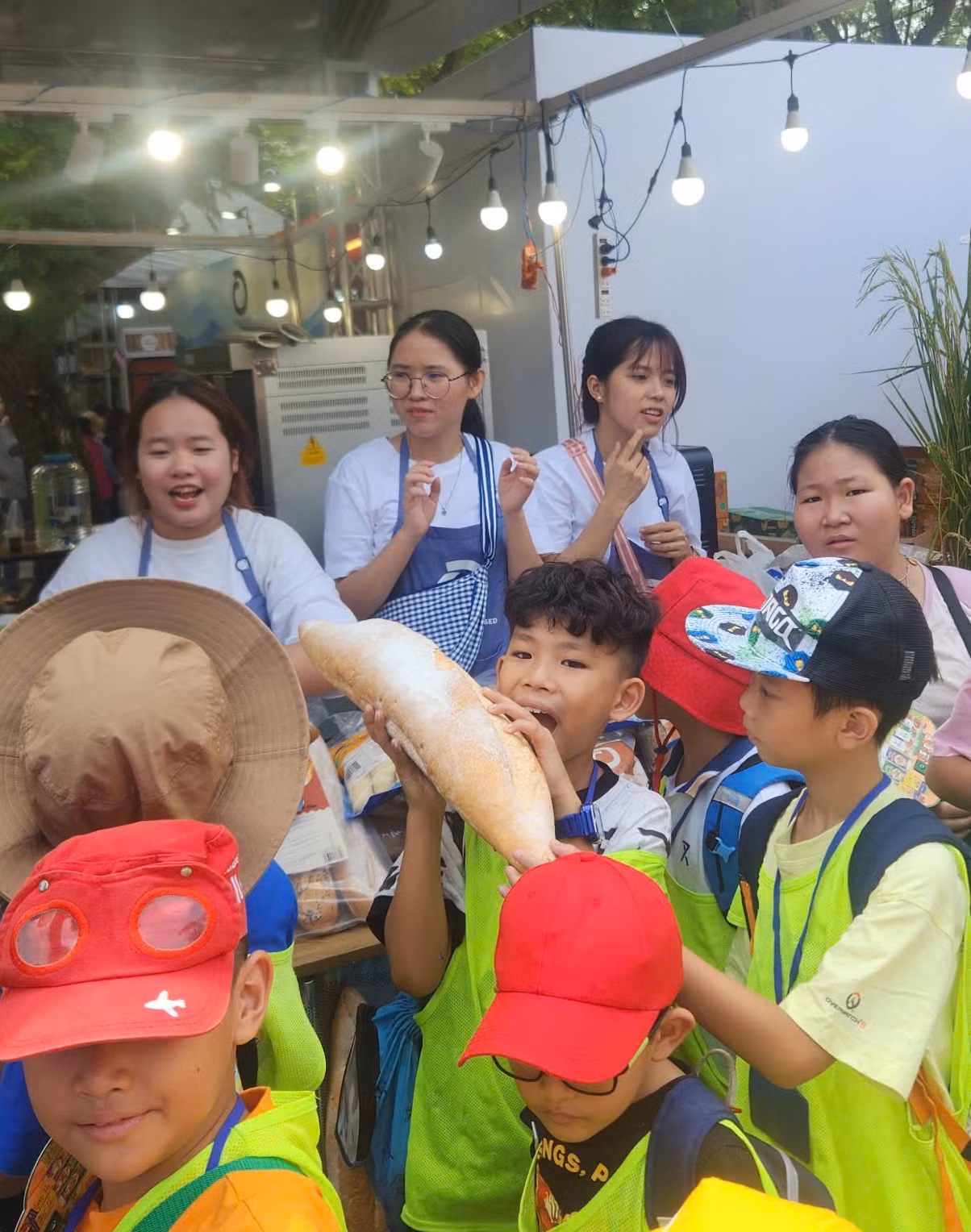 Một em bé đang cố gắng cắn miếng đầu tiên của chiếc bánh mì cỡ đại