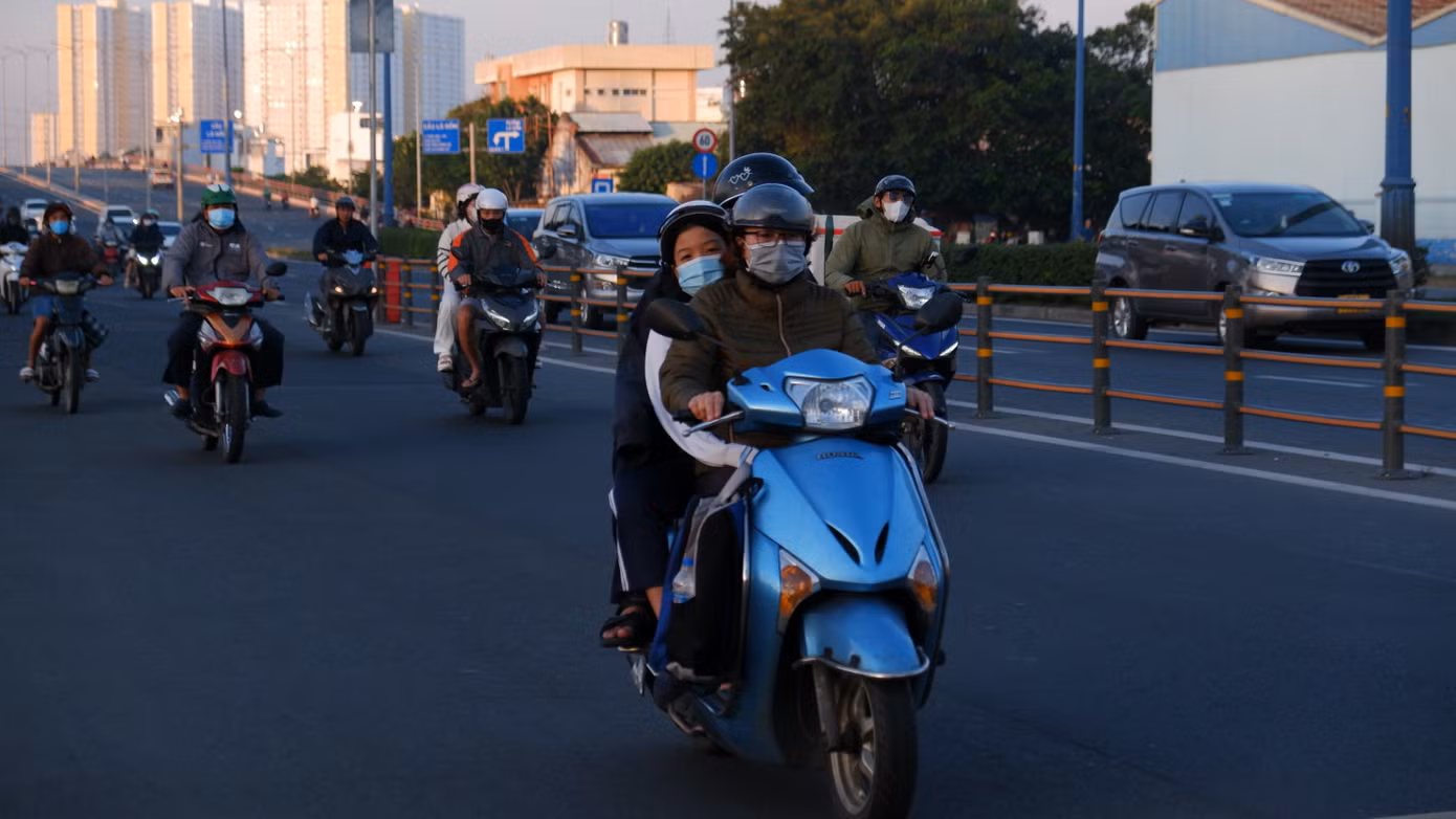 Người đi đường phải khoác thêm áo, đeo bao tay để giữ ấm cơ thể. Ảnh: Hữu Huy