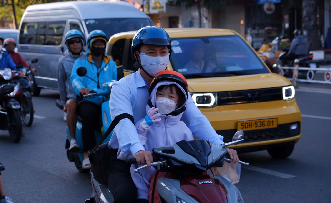 Các em nhỏ được cha mẹ mặc áo khoác, đeo khẩu trang và bao tay để giữ ấm. Ảnh: Hữu Huy