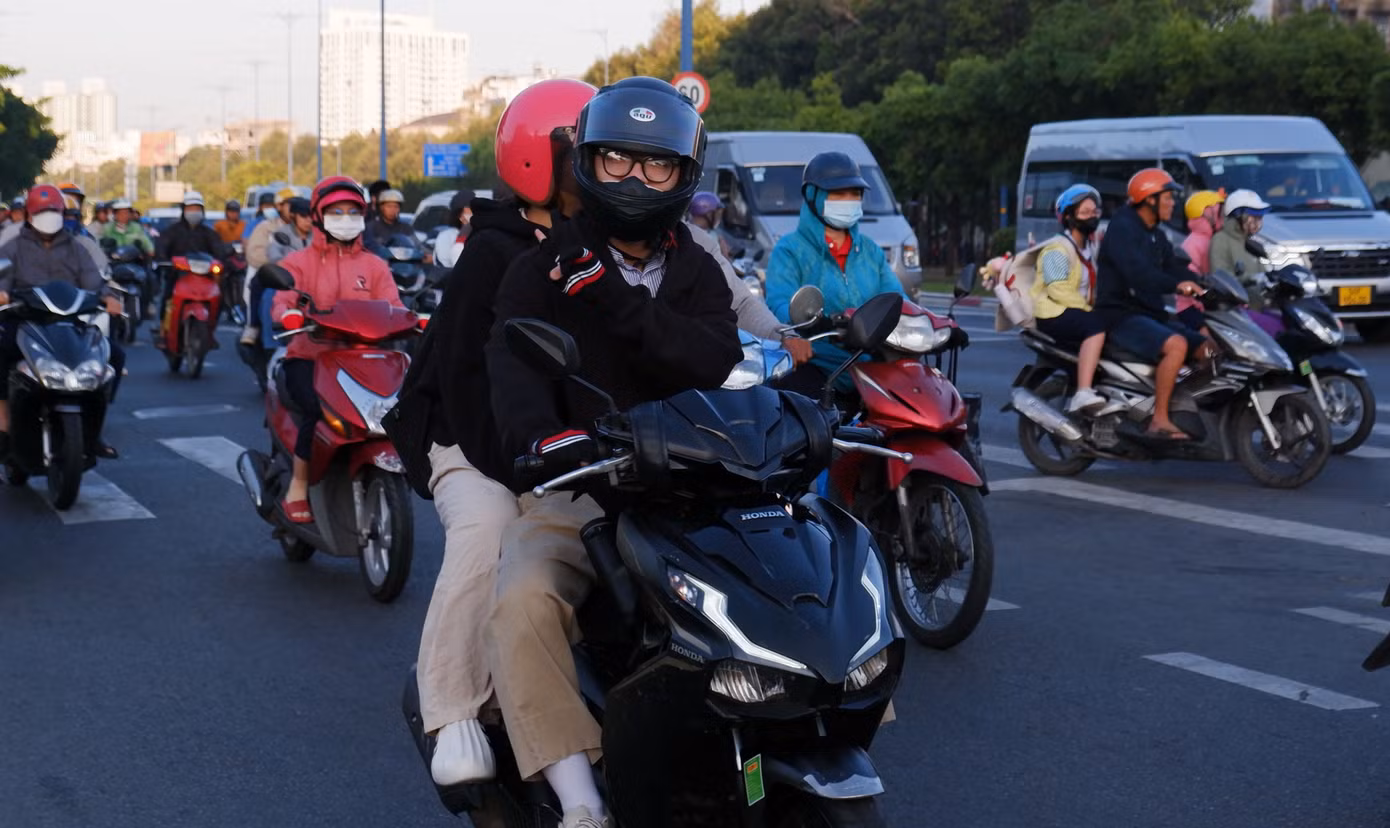 Người đi đường phải khoác thêm áo, đeo bao tay để giữ ấm cơ thể. Ảnh: Hữu Huy